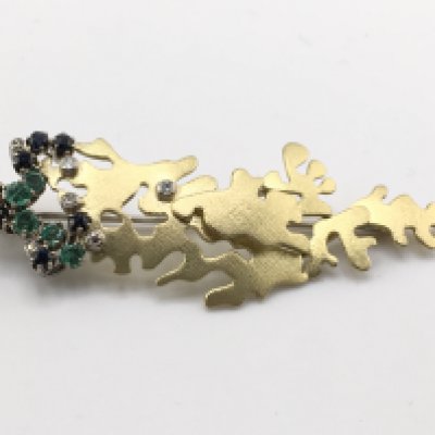 An 18ct gold brooch inset with diamonds sapphires and emeralds. 11.60g and approximately 65mm wide by 20mm. Postage A