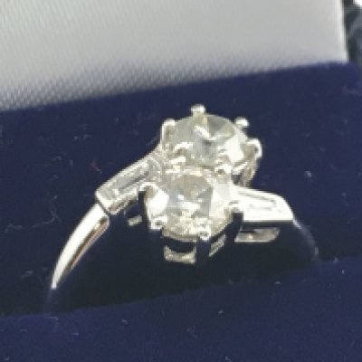 A certificated 18ct white gold twist ring set with two RBC diamonds, with tapered baguette diamond shoulders. RBC diamonds 1.32ct. Baguette diamonds 0.15ct. Cert no. WGI9624147025. Ring weight 4.2g Ring size M