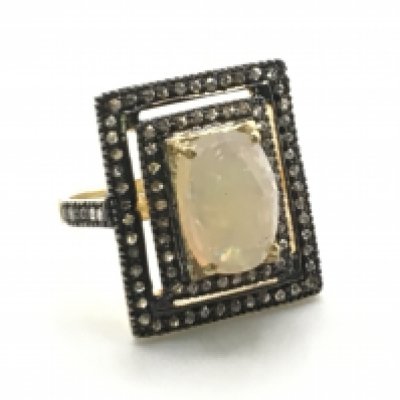 A large rectangular silver gilt dress ring set with an oval cabochon white opal and rose cut diamonds in a double frame. Opal 2.95ct, diamonds 0.94ct. Size O/P. Postage category a
