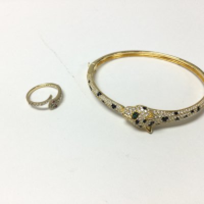 A silver gilt snake ring and silver gilt panther bracelet both set with stones.
