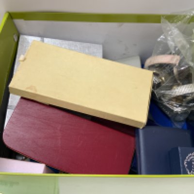 A box of costume jewellery including watches and other oddments.