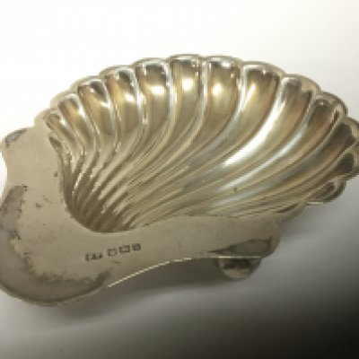 A silver shell shaped dish on small round feet Sheffield hallmarks.
