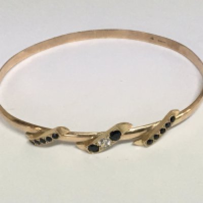 A 9carat gold bangle set with a diamond and sapphire. Weight 11g