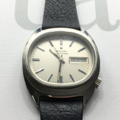 A gents Bulova Accutron day date wrist watch with silver coloured dial and black leather strap. As new condition. Seen running. Postage B