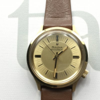 An as new gents Bulova Accutron watch with gold coloured dial and brown leather strap. Seen running. Postage B