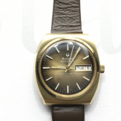 An as new gents Bulova Accutron day date wrist with a brown dial and brown leather strap. Seen working.