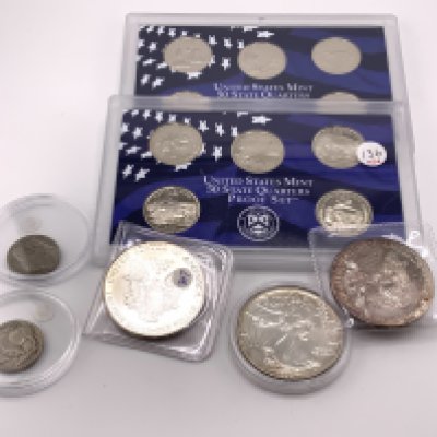 A collection of American coinage to include 3 fine silver 1OZ dollars, 2 Buffalo nickels, 2 cased sets of quarters. (B)