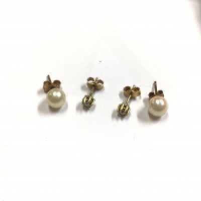 A pair of diamond set earring with a pair of pearl earrings.