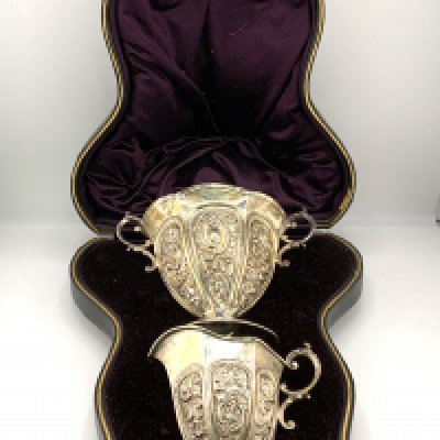 A cased hallmarked silver Jug & Sugar bowl with high relief decoration. Birmingham 1892. (A)
