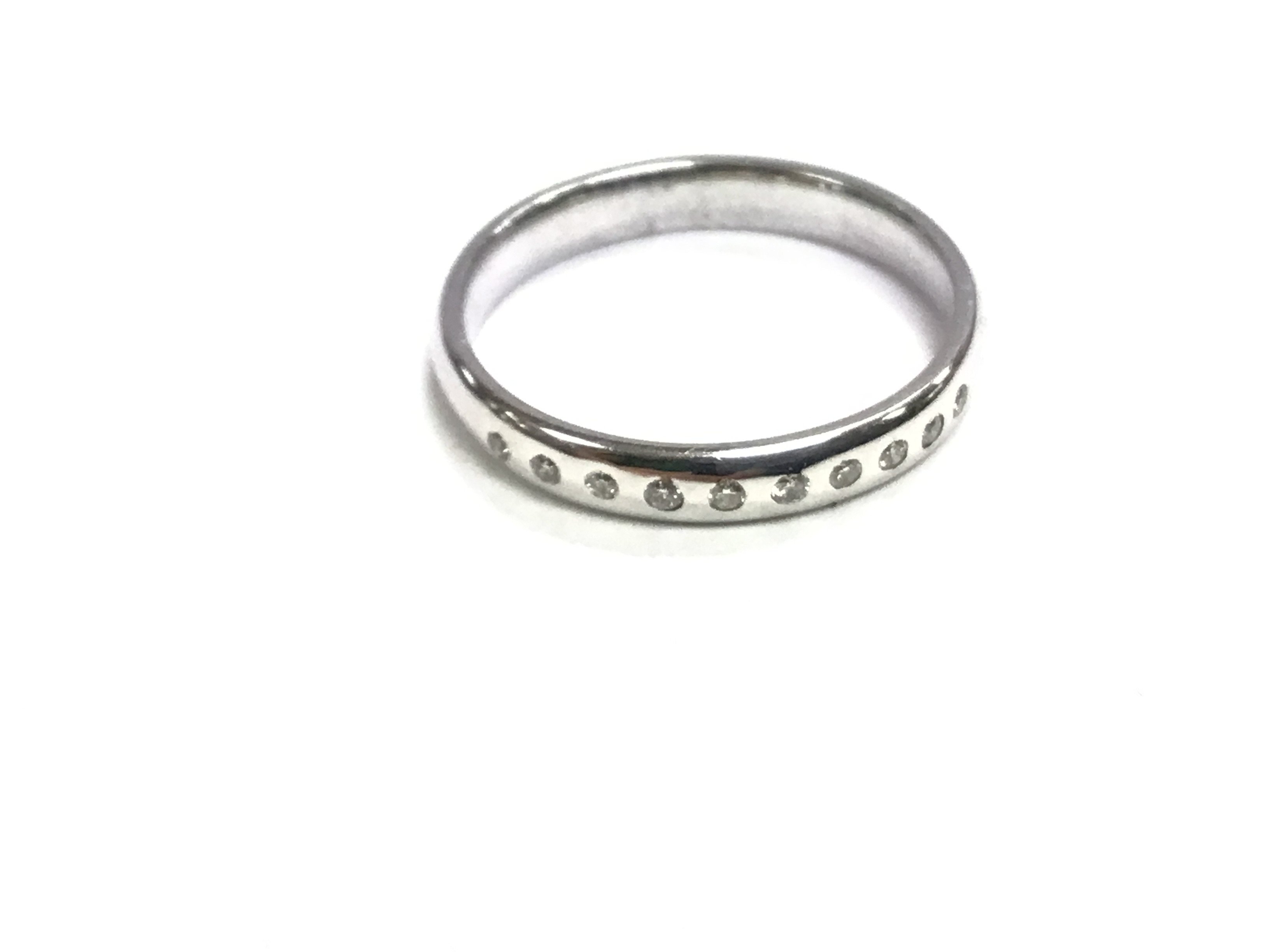 An 18ct white gold wedding rings set with diamonds. 3.4g 0.10ct size O