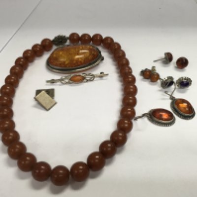 A collection of amber jewellery including brooches, earrings and a necklace.