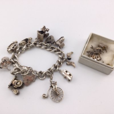 A silver charm bracelet set with multiple charms. Approximately 80g