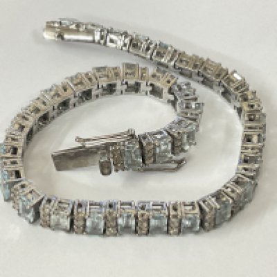 Art deco style articulated bracelet set with baguette cut aquamarines and R/C diamonds, boxed. Aquamarines 9.60ct. Diamonds 2.41ct. Postage category A.