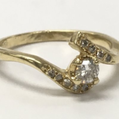 An unmarked gold diamond solitaire swirl ring , 2.6g total weight. Postage category A