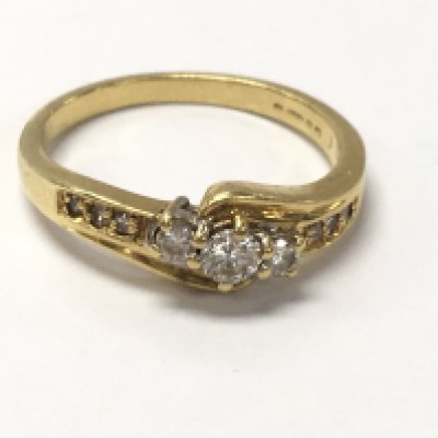 An 18ct gold three stone diamond ring , size N. 3.4g Postage category A
