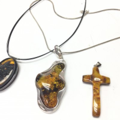 A collection of Amber pendants including one mounted in silver with a silver chain