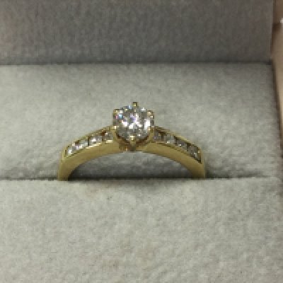 An 18ct gold diamond ring, central stone approximately 0.4/0.5 carat . Flanked by smaller diamonds , 2.9g .size M Postage category A
