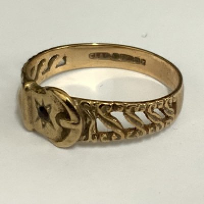 A 9ct gold belt and buckle design ring inset with a small garnet. 2.13 (A)