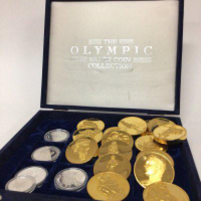 A collection of coins comprising an Olympic silver coin part set five coins a collection of interesting gold plated medallions depicting historical works of art and sculpture.