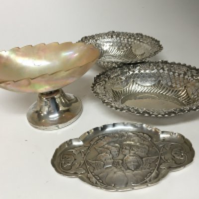 A pair of silver dishes with shaped and pierced edges a pin dish and a silver mounted mother of pearl dish with a shaped edge.