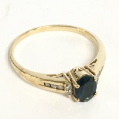 A 9 carat gold ring set with an oval topaz stone and small diamonds. Size U. 2.6g Postage category A