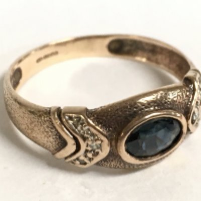A 9 carat gold ring set with a sapphire stone and diamond shards. Size O. 2.1g Postage category A