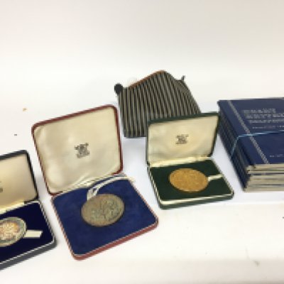 Two silver and one gilded Royal Commemorative Royal Mint medallions Prince Charles investiture and a quantity of Great Britain blue penny and bronze coin collectors albums and a bag of loose used circulated coinage.