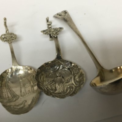Two Continental silver spoons repousse decorated with figures and buildings and an unmarked sugar spoon. (3)