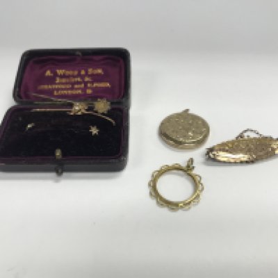 A vintage 9ct gold brooch with some stick pins and other gold items.