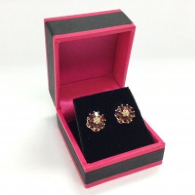 A pair of 9ct gold earrings set with garnets in the form of a flower, postage category A