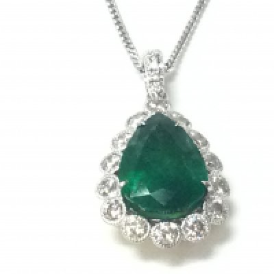 An 18ct white and yellow gold pendant set with a pear shaped emerald surrounded by RBC diamonds in a beaded setting with diamond bale on a silver chain. Emerald 2.85ct and 0.66ct diamonds approx. Postage B