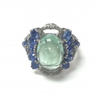 A large cluster ring in silver set with an oval cabochon tourmaline surrounded by oval kyanite and diamonds. Tourmaline 7.33ct Kyanite 3.09ct and diamonds 0.36ct approximately. Size N 1/2 Postage A