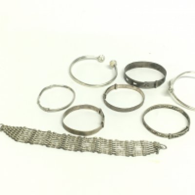 A collection of silver bangles and a gate bracelet, 75g in total. Postage category A- NO RESERVE