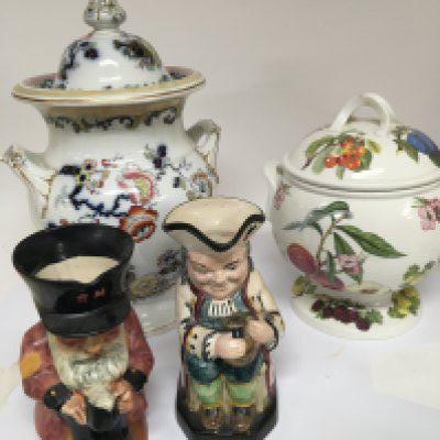 A Victorian Porcelain large size storage jar and cover, highttwo Caricature jugs and a large Portmeirion storage jar and cover. (4)