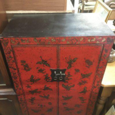 A 20th century Vietnamese red lacquer cabinet with butterfly and floral design, dimensions 42x70x120cm