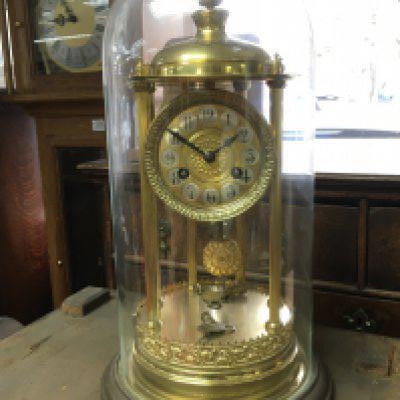 An early 20th century clock under a glass dome, 42cm tall. this lot cannot be posted