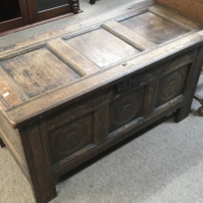 A late 18th century English oak vernacular chest with a hinged panel top above further carved panels. length 105cm x 48cm