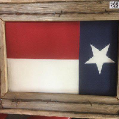 Texas&rsquo;s cloth flag in pine frame surrounded by barb wire ,