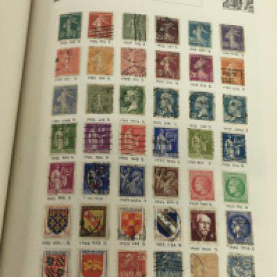 An international stamp album containing a good collection of World stamps including early 20th century world stamps cigarette card albums and other ephemera.