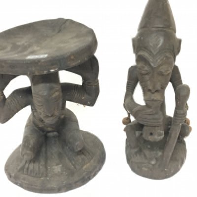 A carved hardwood African seat the circular top supported by a figure and one other African tribal carving (2)