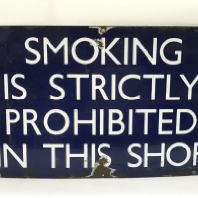 An enamel shop sign 'Smoking Is Strictly Prohibited In This Shop', approx 46cm x 30cm. Shipping category D.