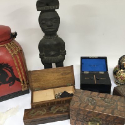 A carved hardwood tribal figure carved wood boxes a leather jewellery box and Russian doll and other items.