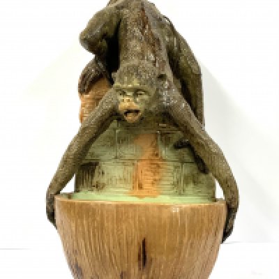 A continental majolica pottery wall pocket in the form of a monkey holding a coconut, hand painted date cypher to reverse . 25cm. (D) some damage to tail.