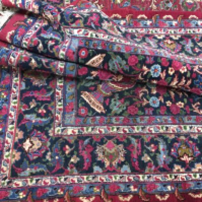 A large hand knotted rug with vibrant colours. Approximately 390 cm by 300