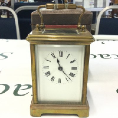 A wooden and leather cased carriage clock (11cm tall) , made in France. This lot cannot be Oates