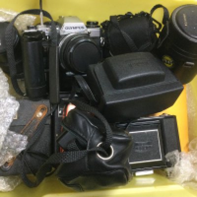 A box of camera equipment comprising an Olympus OM10, Zeiss Ikon etc. Shipping category D.