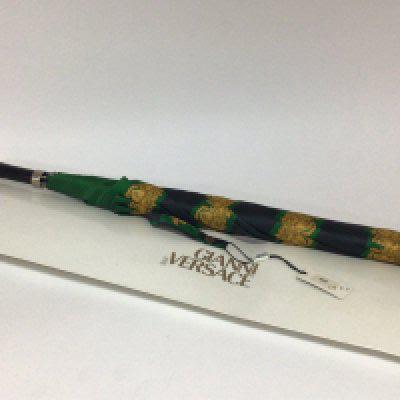 An unused Gianni Versace umbrella with attached tag and outer cardboard packaging.