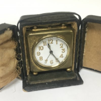 A Vintage traveling clockwork alarm clock in a fitted case. NO RESERVE