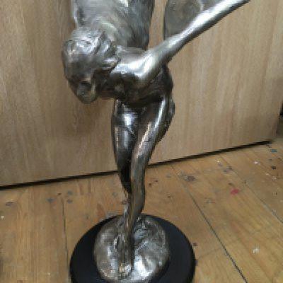 A large figure of the Spirit of Ecstasy . On a marble base .