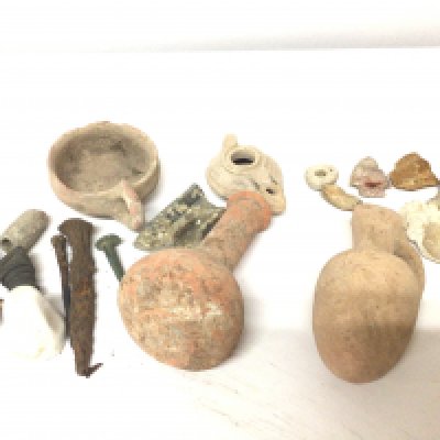 A collection of Roman Antiquitys clay pots and an oil light other archaeological finds including arrow head flints nails etc.
